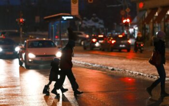 Fußgänger überqueren Straße im Dunklen