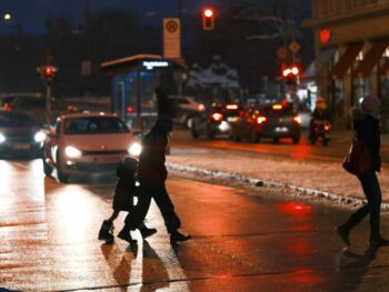 Fußgänger überqueren Straße im Dunklen