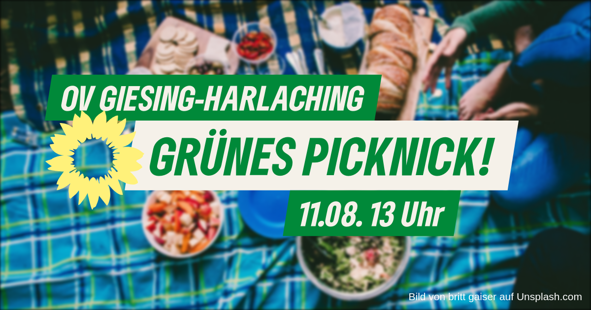 Text in grüner Farbe, der ankündigt: OV Giesing-Harlaching, Grünes Picknick!, 11.08. 13 Uhr; Im Hintergrund ist verschwommen eine gedeckte Picknickdecke zu sehen